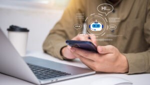 Mann hält Smartphone, während ein virtueller Chatbot mit „Hi…“ erscheint – moderne Anwendung von voice KI für digitalen Kundenservice.